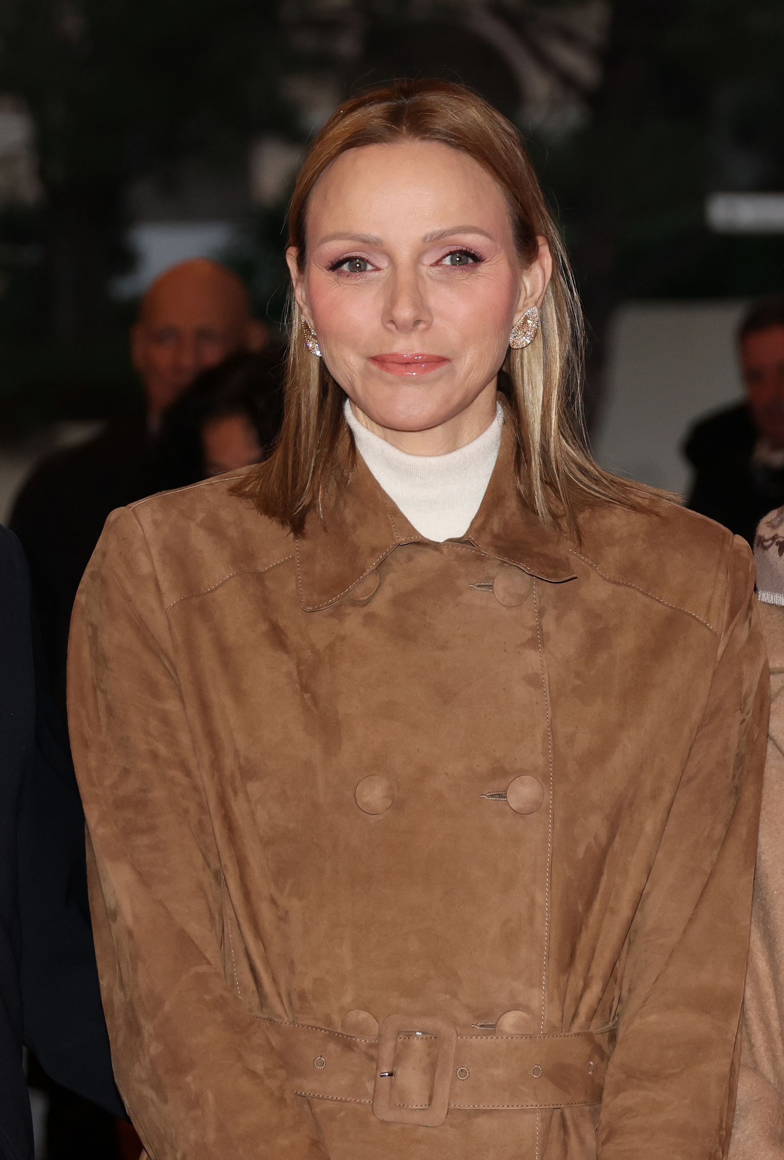 Charlene de Mónaco con un abrigo gabardina camel